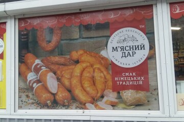  «Ковбасна» реклама на зупинці громадського транспорту в Луцьку